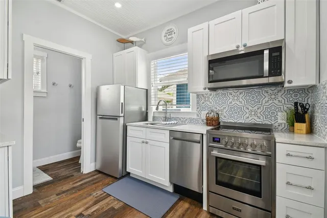 a kitchen with stainless steel appliances a stove microwave and refrigerator
