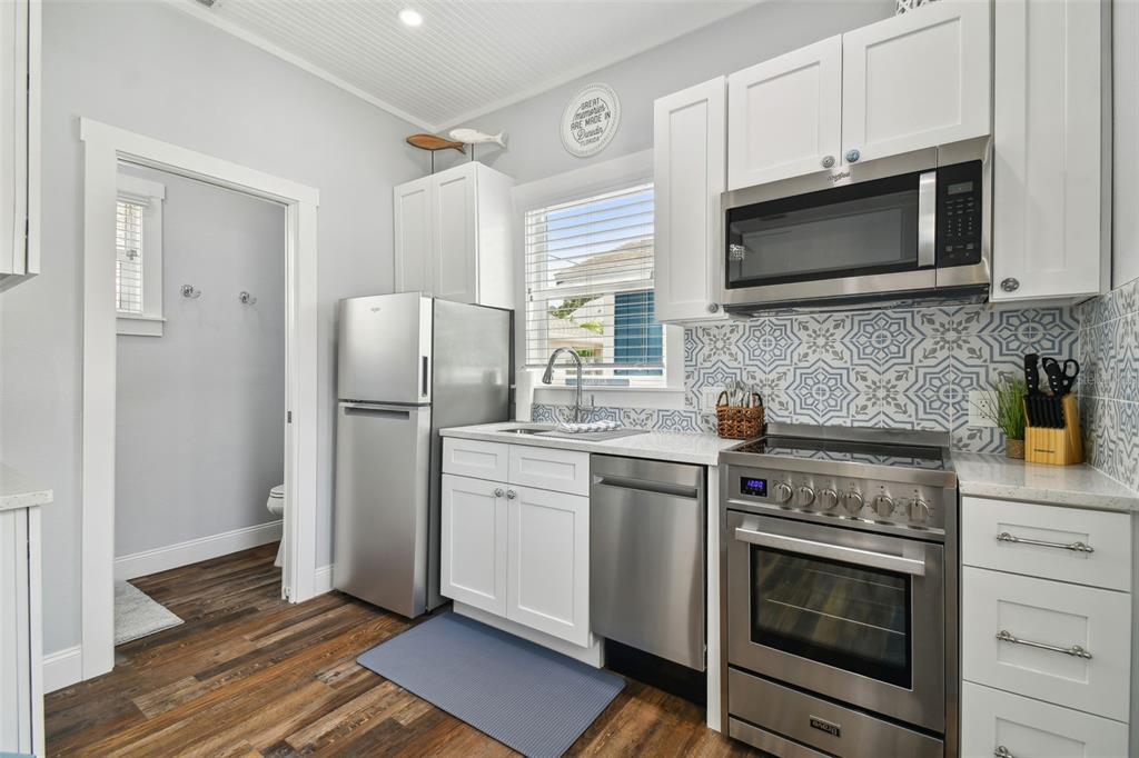 602 Skinner Boulevard Dunedin, FL 34698 - Photo 3 of 27 a kitchen with stainless steel appliances a stove microwave and refrigerator
