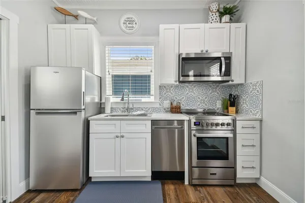 a kitchen with white cabinets and stainless steel appliances