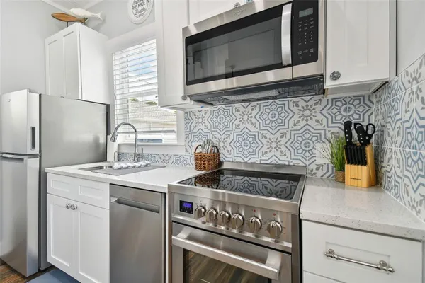 a kitchen with stainless steel appliances granite countertop a stove microwave and sink