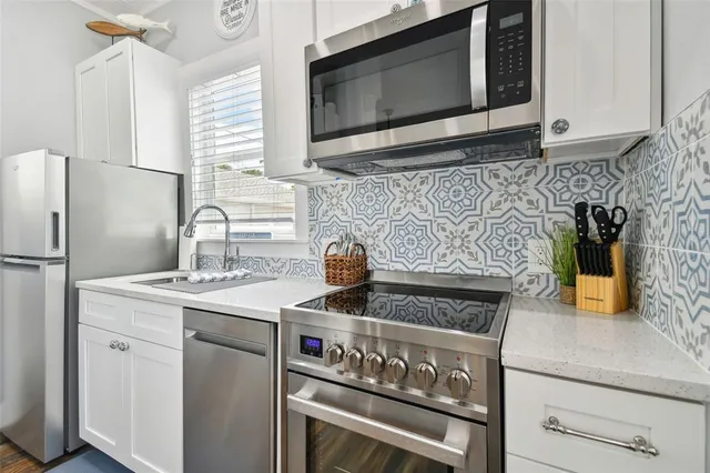 a kitchen with stainless steel appliances granite countertop a stove microwave and sink