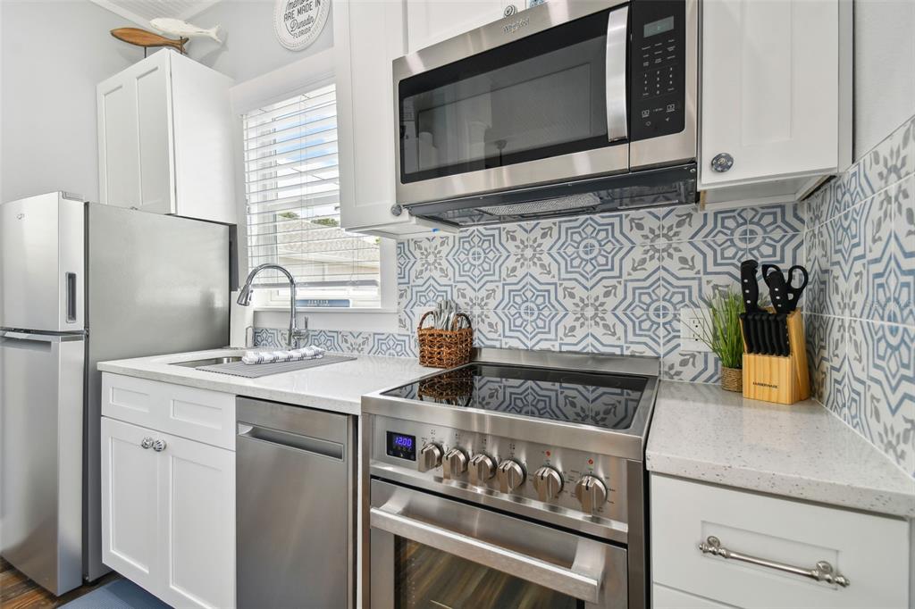 602 Skinner Boulevard Dunedin, FL 34698 - Photo 7 of 27 a kitchen with stainless steel appliances granite countertop a stove microwave and sink