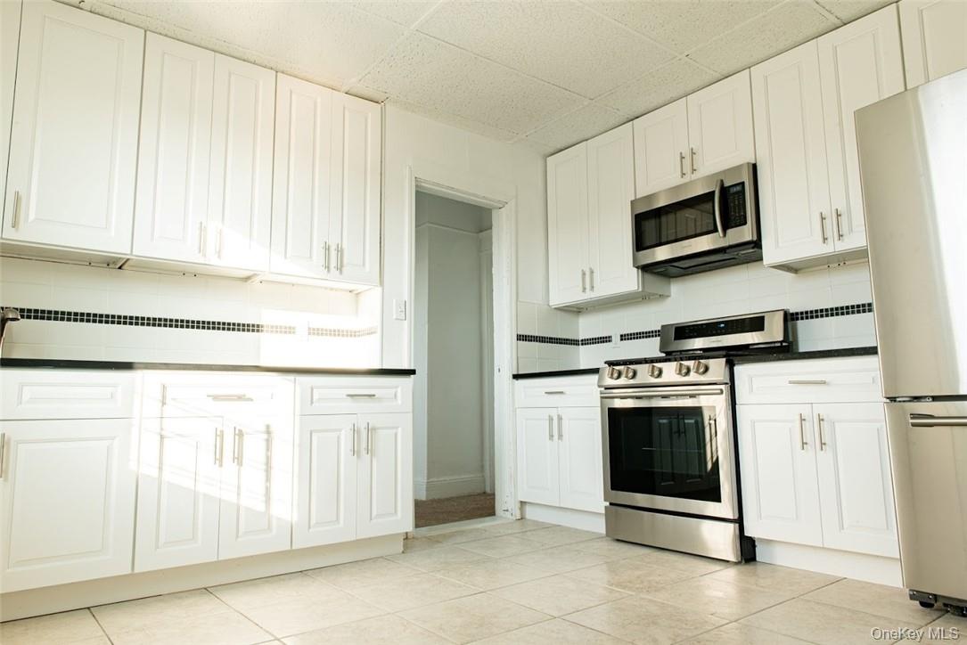 a kitchen with stainless steel appliances granite countertop a refrigerator and a stove top oven