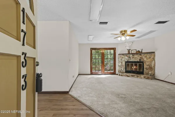 a big room with chandelier fan and windows