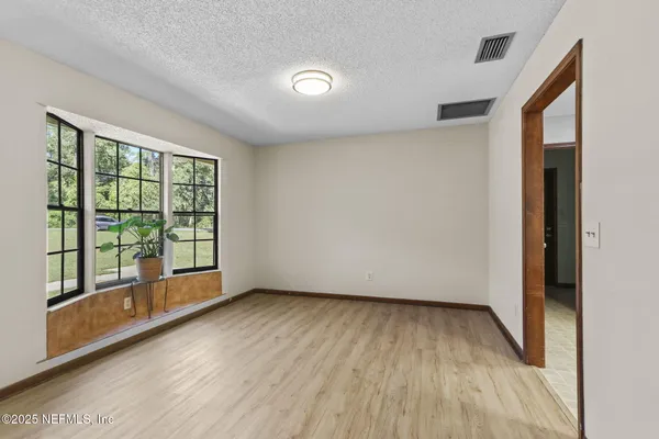 a view of room with window and wooden floor