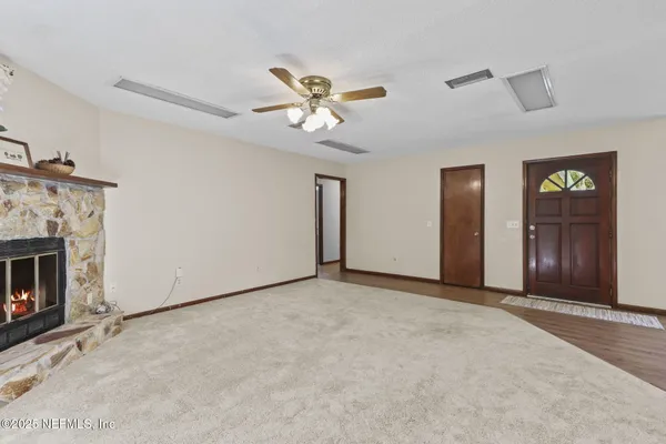 a view of an empty room with closet and a fireplace