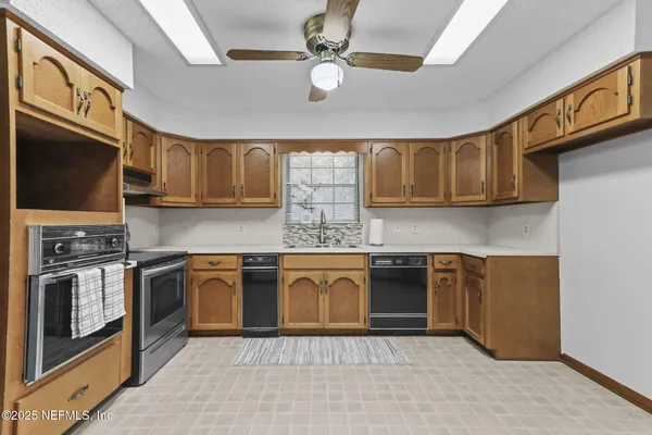 a kitchen with stainless steel appliances granite countertop a refrigerator a stove top oven a sink and dishwasher