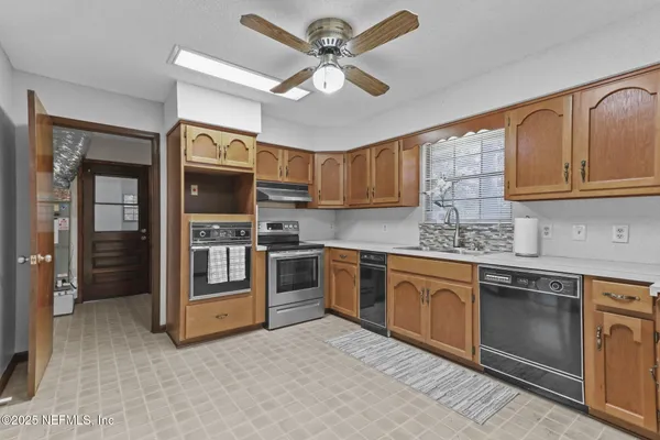 a kitchen with granite countertop a stove sink and cabinets
