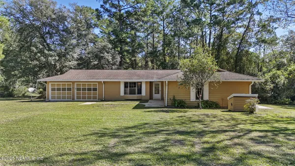 a front view of house with yard and trees