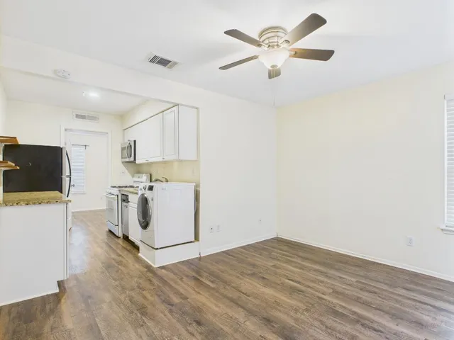 a view of a workspace with furniture and a ceiling fan