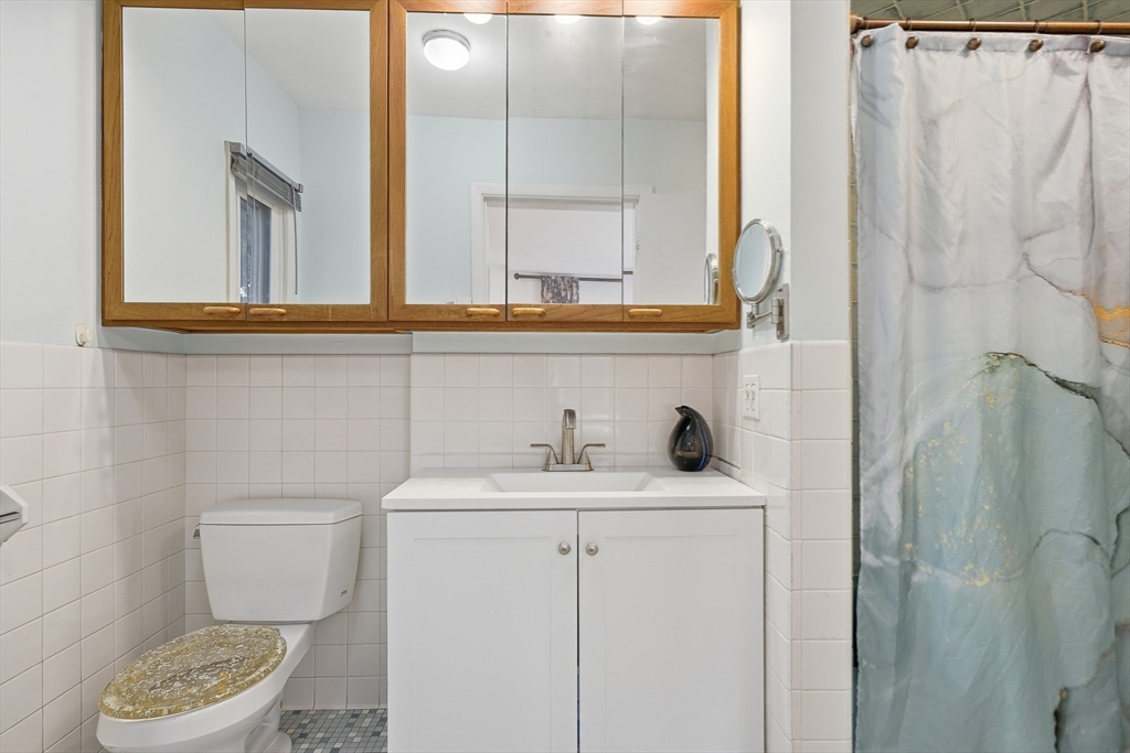 184 Rawson Road Brookline, MA 02445 - Photo 19 of 29 a bathroom with a granite countertop sink and a toilet