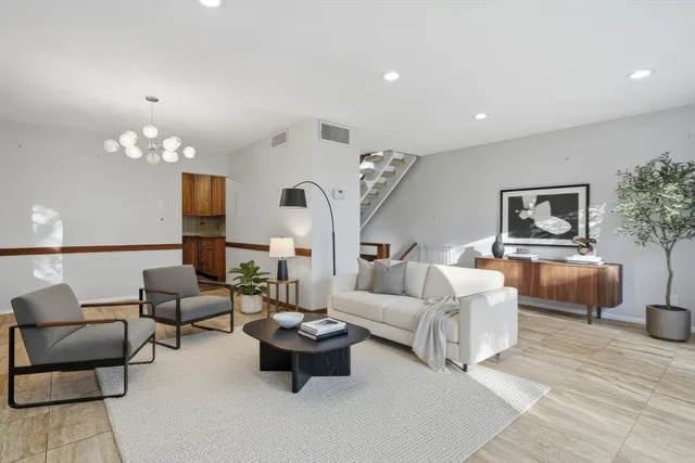 a living room with furniture and a chandelier
