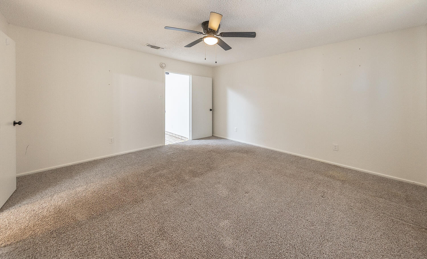 4706 78th Street Lubbock, TX 79424 - Photo 17 of 43 a view of a room with a ceiling fan and a window