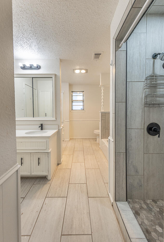 4706 78th Street Lubbock, TX 79424 - Photo 18 of 43 a bathroom with a sink a toilet and shower