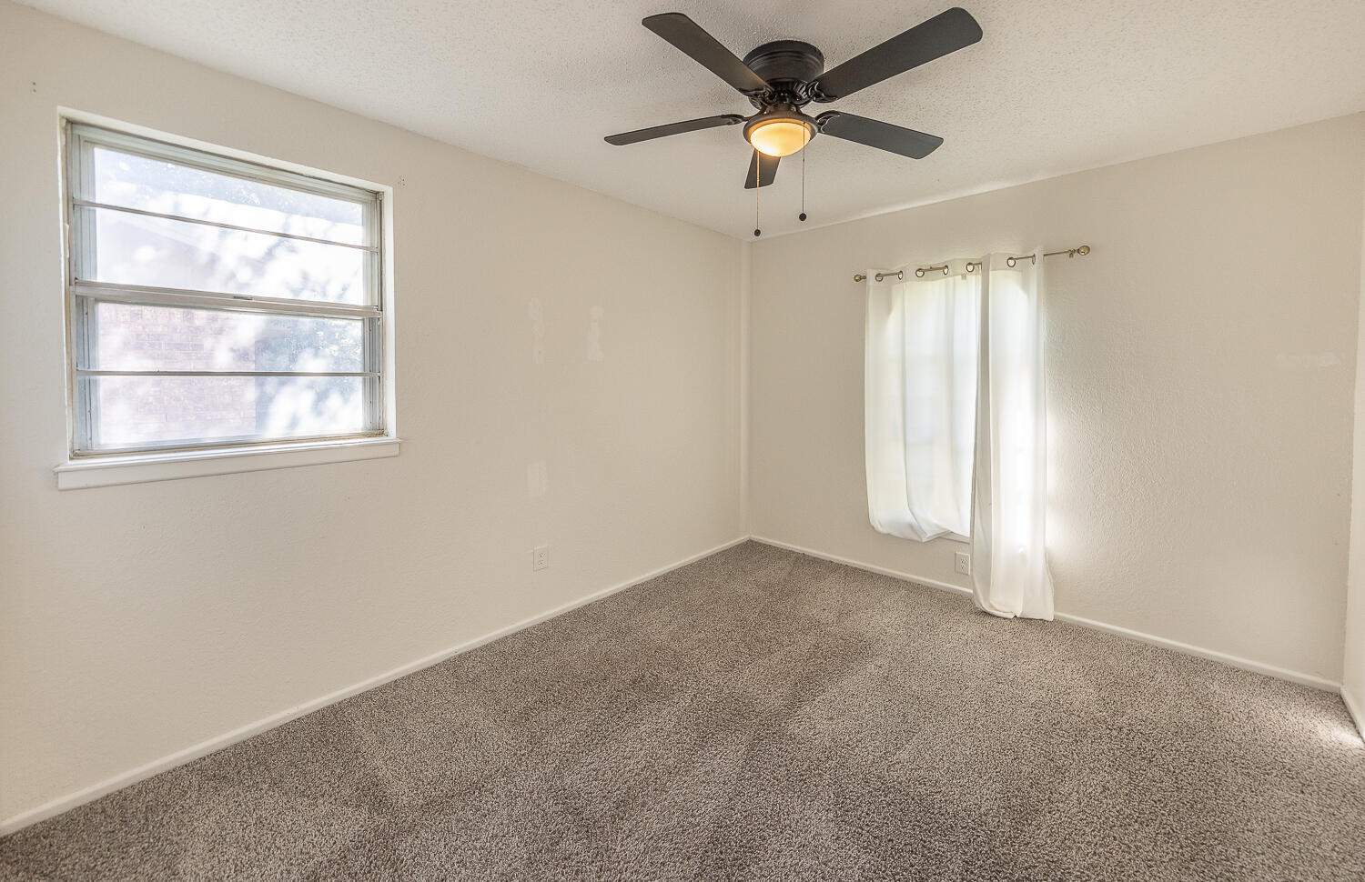 4706 78th Street Lubbock, TX 79424 - Photo 25 of 43 an empty room with windows and fan