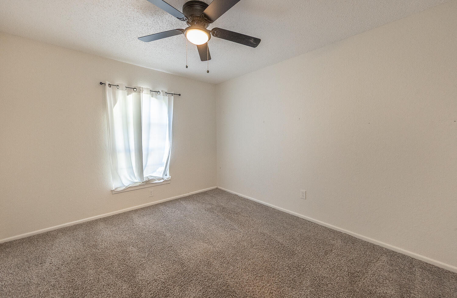 4706 78th Street Lubbock, TX 79424 - Photo 27 of 43 an empty room with a window and a fan