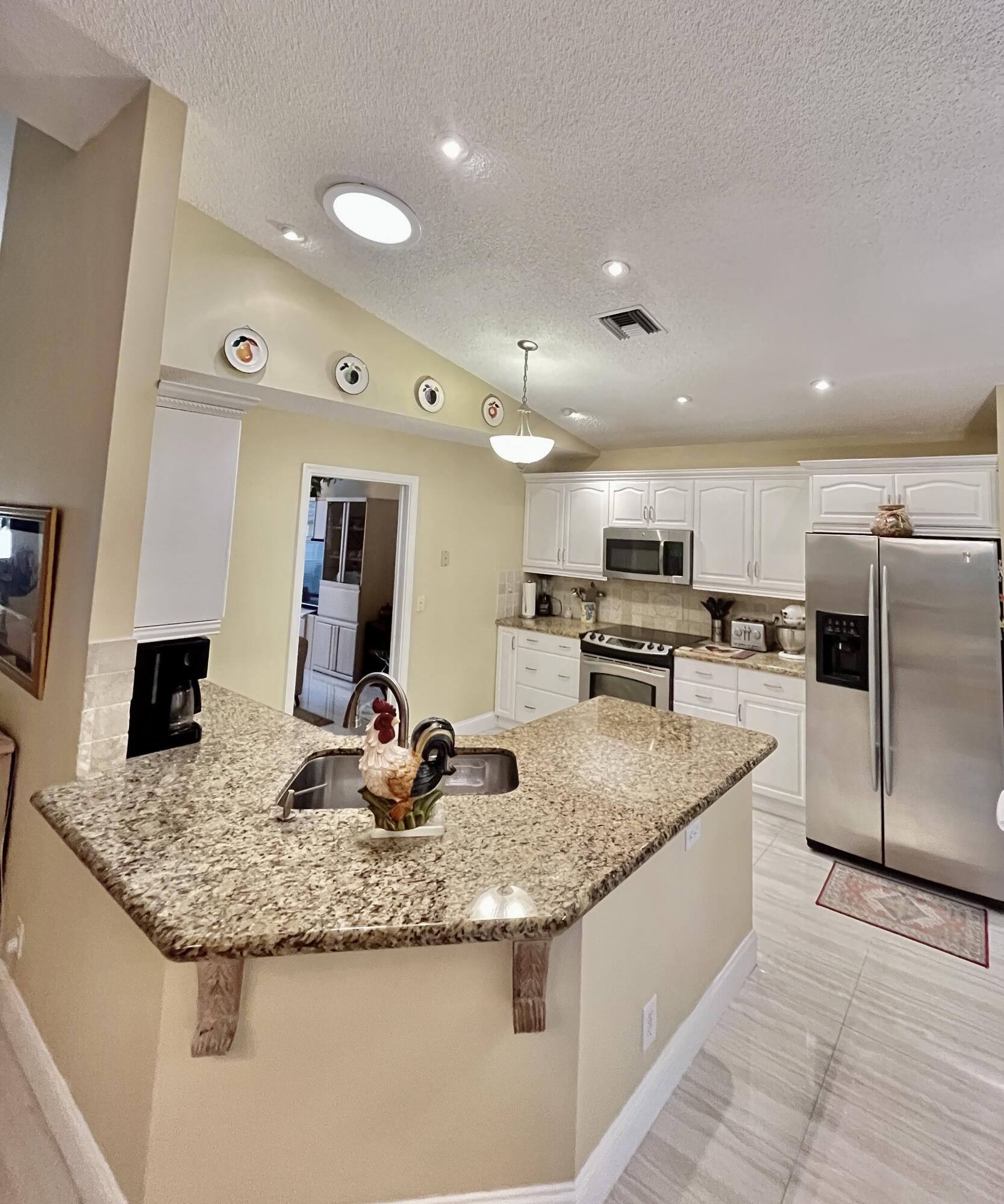 151 St Michaels Court Jupiter, FL 33458 - Photo 17 of 41 a kitchen with stainless steel appliances granite countertop a sink and cabinets