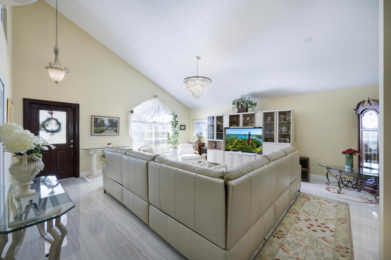 151 St Michaels Court Jupiter, FL 33458 - Photo 29 of 41 a living room with furniture a flat screen tv and a table