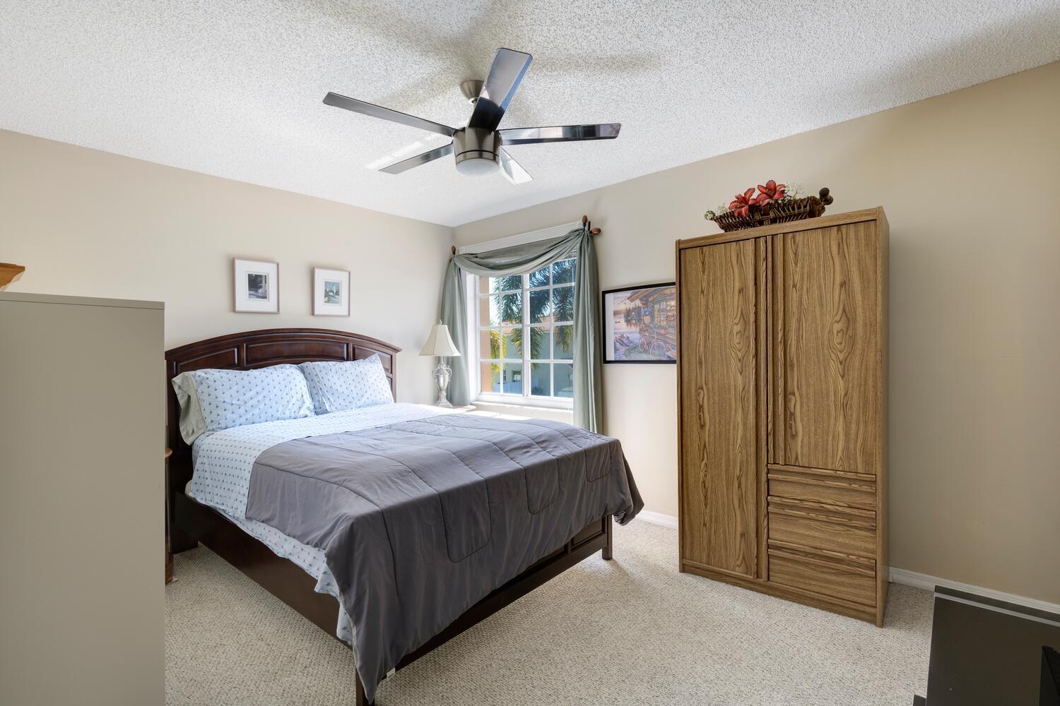 151 St Michaels Court Jupiter, FL 33458 - Photo 34 of 41 a bed room with a bed and a ceiling fan