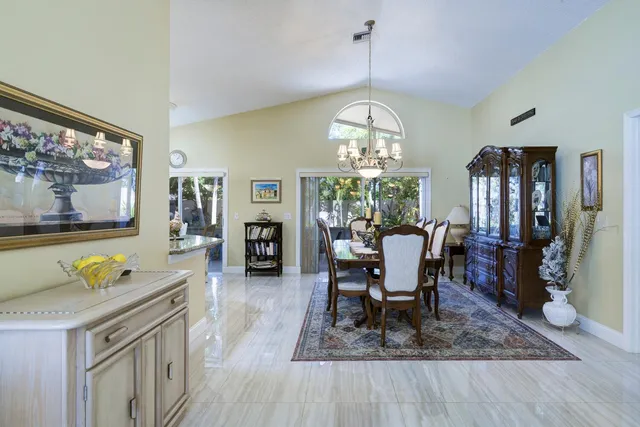 a view of a dining room with furniture a chandelier and wooden floor