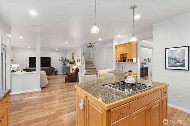 a kitchen with kitchen island a large counter top space a sink stainless steel appliances and cabinets