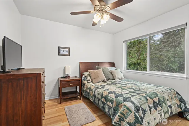 a bedroom with a large bed and a flat tv screen on dresser