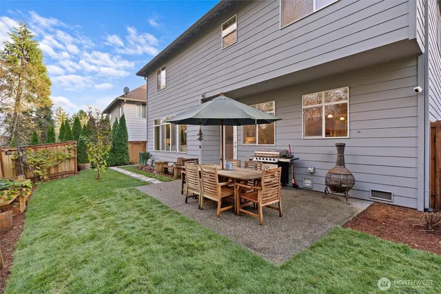 a view of a house with backyard and sitting area