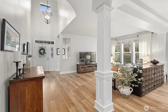 a living room with furniture large window and wooden floor