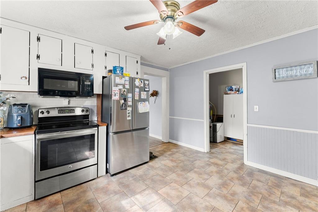 2000 Dr Bramblett Road Cumming, GA 30040 - Photo 10 of 37 a kitchen with stainless steel appliances a stove a microwave and white cabinets