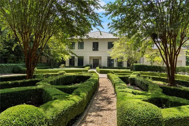 a view of a house with a big yard and large trees