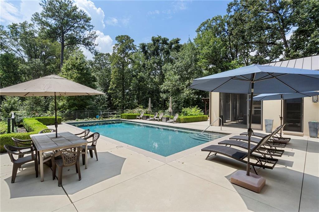 1500 West Wesley Road Northwest Atlanta, GA 30327 - Photo 49 of 60 a view of pool with table and chairs under an umbrella