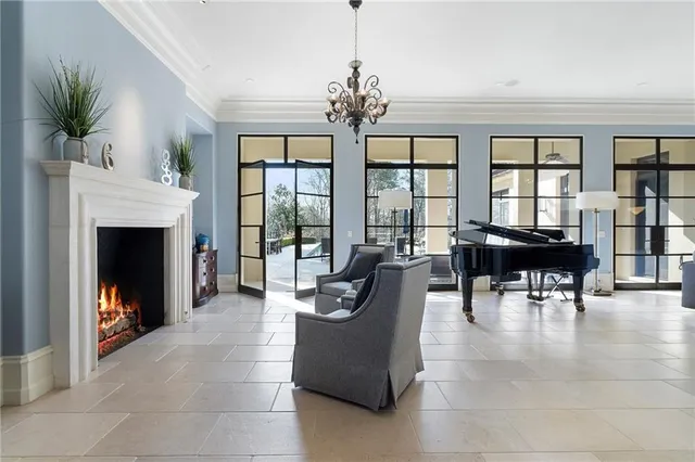 a living room with furniture a fireplace and a floor to ceiling window