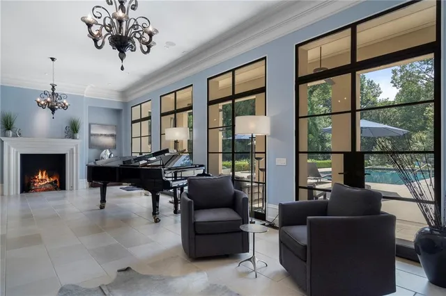 a living room with furniture a fireplace and a chandelier