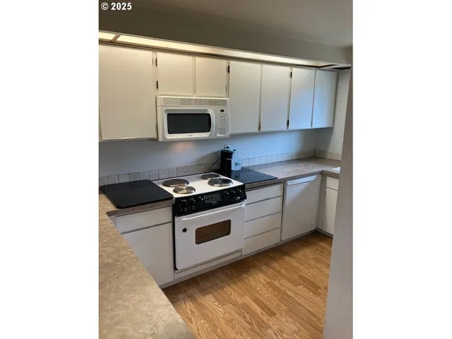 a kitchen with stainless steel appliances white cabinets and a stove