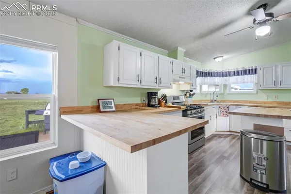 a kitchen with a stove a sink dishwasher and a refrigerator with wooden floor