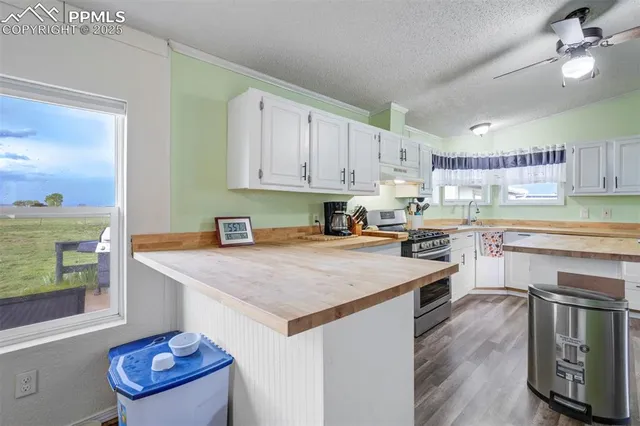 a kitchen with a stove a sink dishwasher and a refrigerator with wooden floor