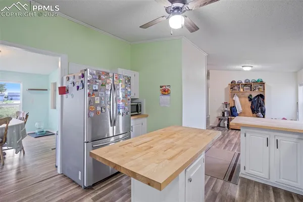 a room with kitchen island a wooden floor and chandelier