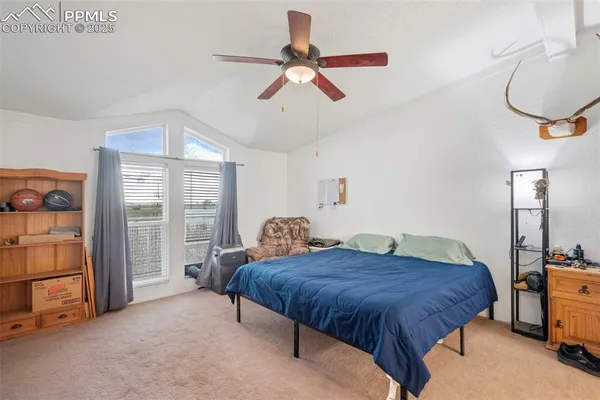 a spacious bedroom with a bed and a chandelier