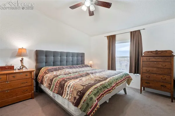 a bedroom with a bed and a ceiling fan