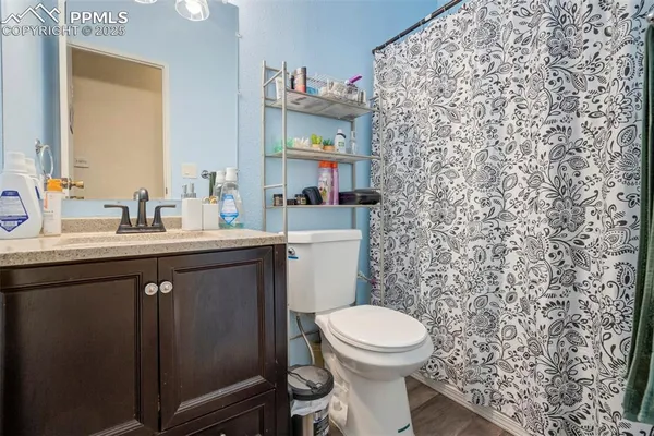 a bathroom with a granite countertop toilet sink and mirror