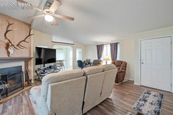 a living room with furniture a flat screen tv and a fireplace