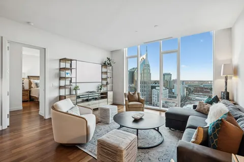 a living room with furniture wooden floor and a large window