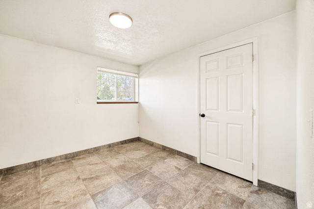 365 South Center Street Fielding, UT 84311 - Photo 23 of 41 Empty room with stone finish flooring and a textured ceiling