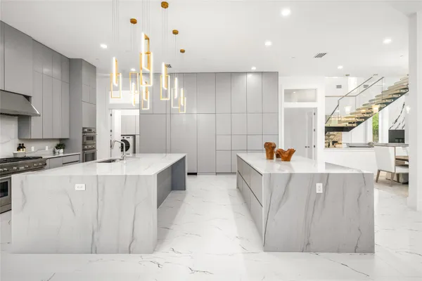 a kitchen with stainless steel appliances a table and chairs in it