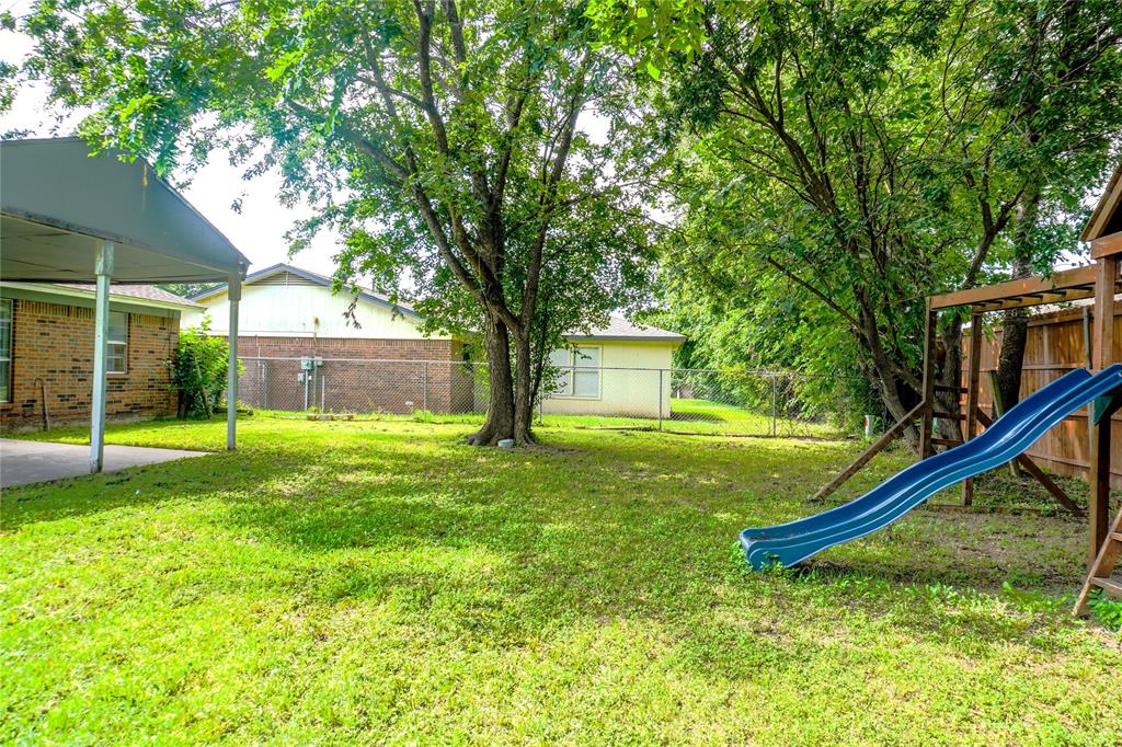 300 Coury Road Everman, TX 76140 - Photo 23 of 29 a view of a house with a backyard and a tree