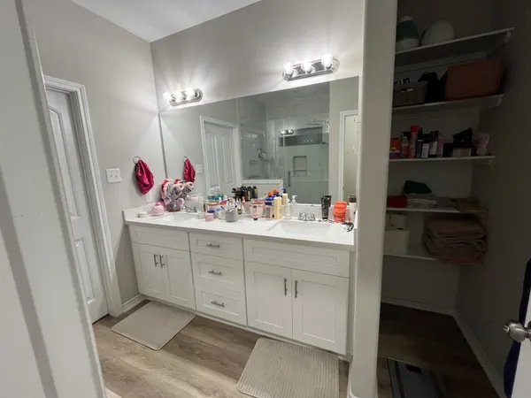 a bathroom with a double vanity sink mirror and toilet