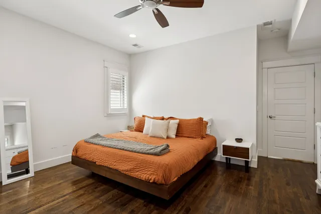 a bedroom with a bed and wooden floor