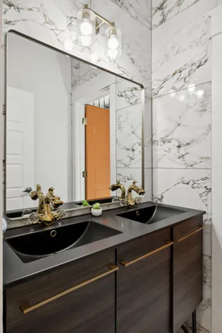 a bathroom with a granite countertop sink and glass door