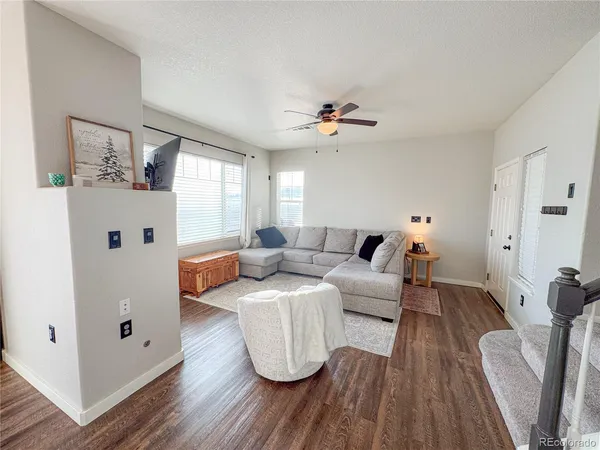 a living room with furniture and wooden floor