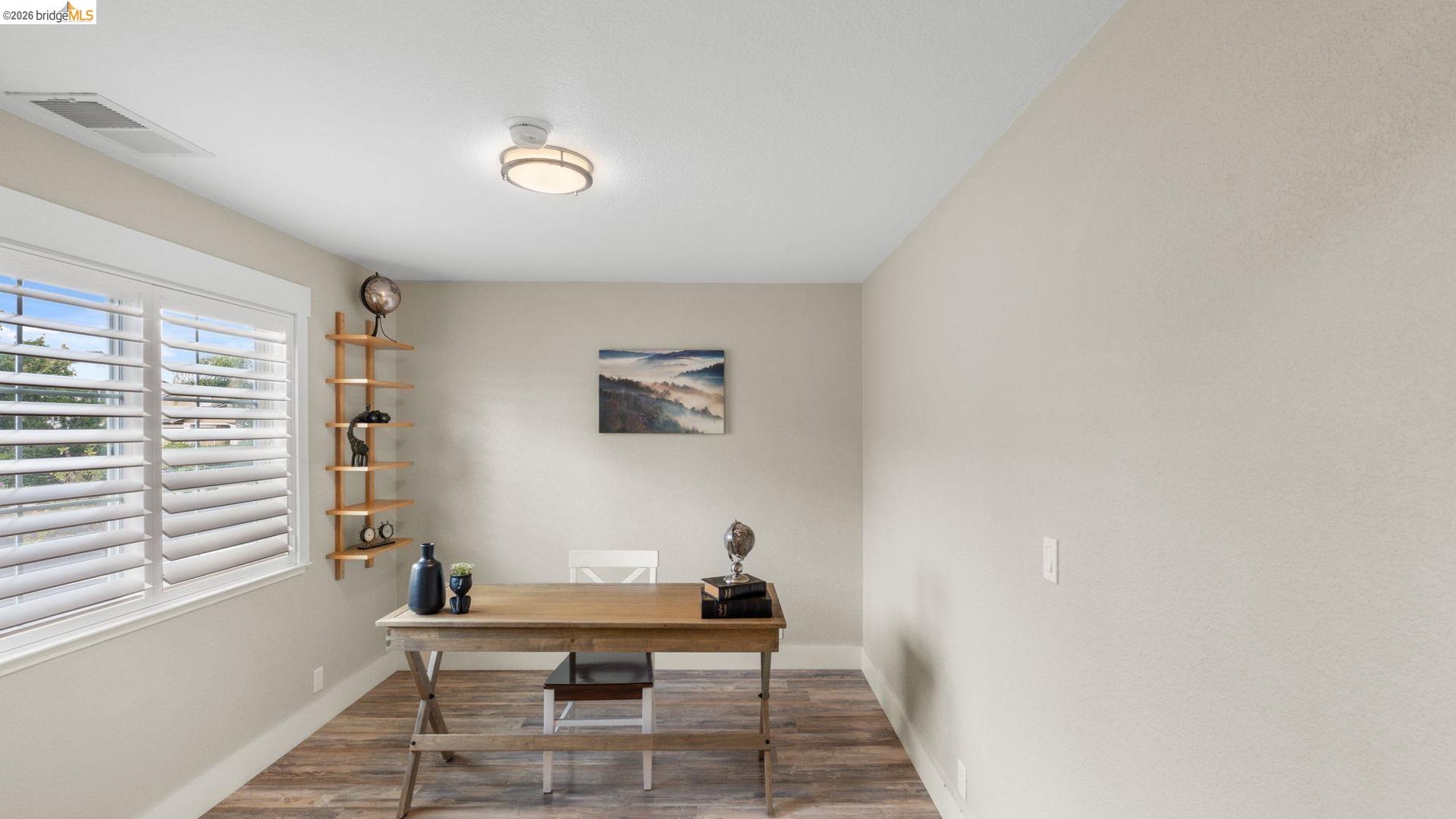 700 Brownstone Road Oakley, CA 94561 - Photo 14 of 58 Room featuring wood-finish flooring, a contemporary flush-mount ceiling light fixture, and a window with white plantation shutters